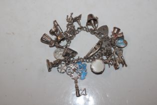A silver charm bracelet with approx. 20 silver and
