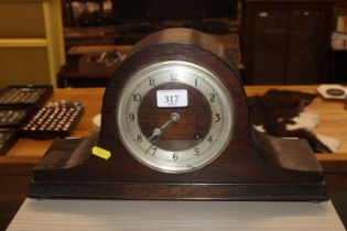 An oak cased twin hole mantel clock