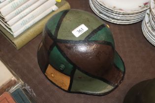 A German WWI 1916 patent helmet with camo paint fi