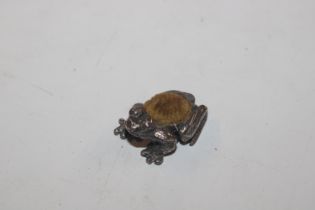 A white metal pin cushion in the form of a frog
