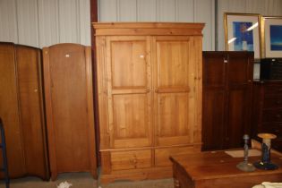 A pine two door wardrobe with hanging rail and she