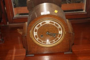 An oak cased Art Deco two hole mantel clock