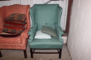 A green upholstered wing back armchair