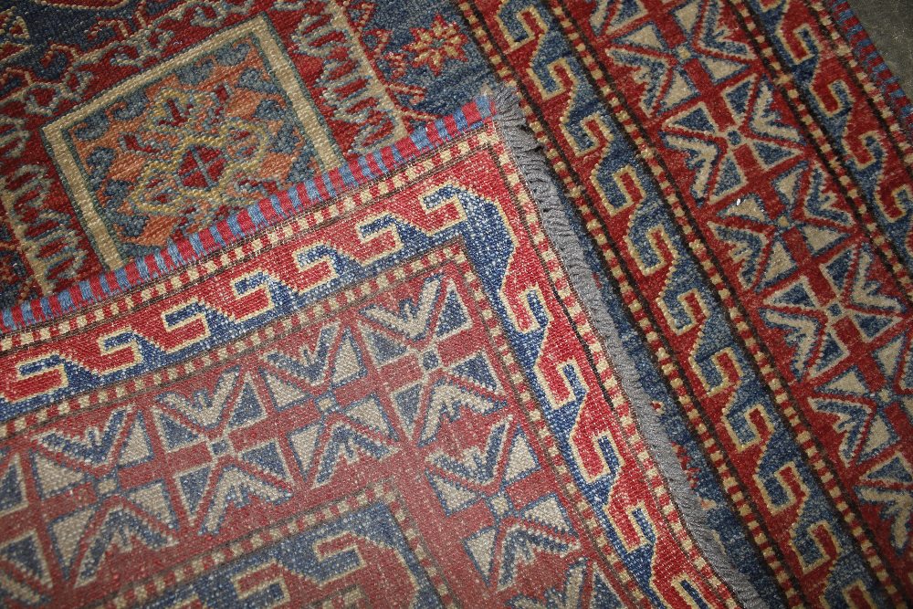 An approx. 4'4" x 3' red and blue pattern wool rug - Image 3 of 3