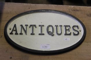 A painted oval cast iron sign for "Antiques" (165)