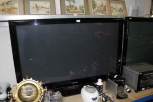 A large Samsung flat screen tv with remote control