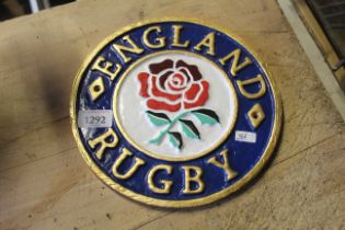 A painted circular cast iron sign for "England Rug