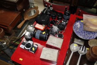 A quantity of cameras including Nikon F80, Nikon Coolpix, lenses and four boxes of Magic Lantern