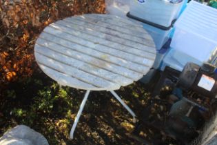 A circular plastic topped slatted garden table