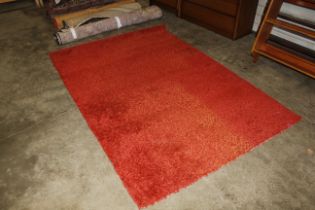 An approx. 7'5" x 5'4" red wool rug