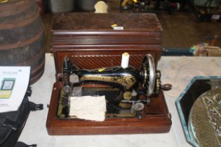 A Singer hand sewing machine in fitted wooden case