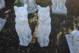 A pair of cast concrete garden ornaments in the form of Siamese cats