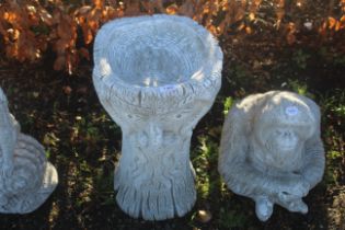 A cast concrete garden bird bath in the form of th