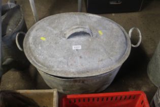 A galvanised twin handled bath with lid