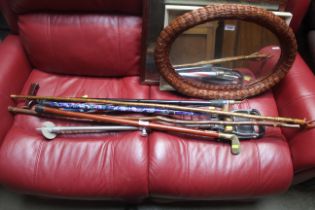 A quantity of various walking sticks, shooting sti