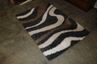 An approx. 5'8" x 4' black white and brown pattern