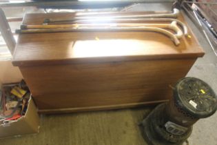 A large wooden storage box with hinged lid on cast