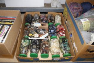 A large box of bottles containing various buttons