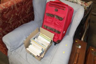 A small red suitcase and a box containing walking