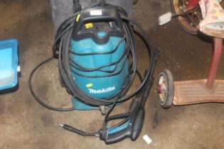 A Makita HW102 pressure washer with lance and acce