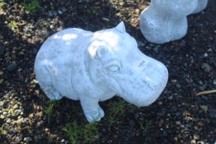 A cast concrete garden ornaments in the form of a seated baby hippopotamus