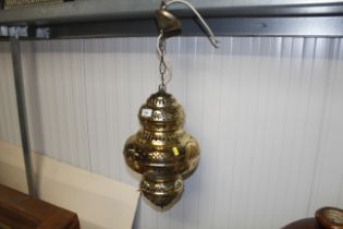 An ornate pierced brass hanging electric lantern