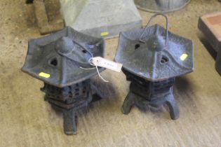A pair of cast iron oriental style hanging candle lanterns