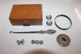 A small case containing silver handled button hook