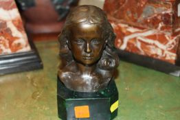 A bronzed bust of a girl on faux marble plinth