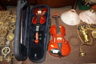 A three quarter size violin and a half size violin