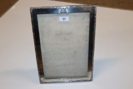 A large silver photo frame mounted with a crest ap