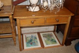 An antique stripped pine two drawer side table
