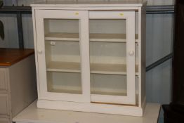 A white painted china cabinet with glass sliding d
