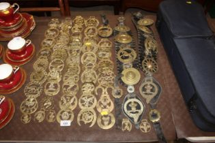 A collection of horse brasses some on leather stra
