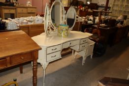 A cream and gilt decorated dressing table with tri