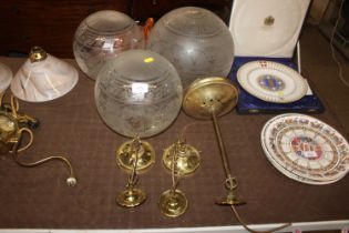 A pair of brass light fittings and another similar with glass shades