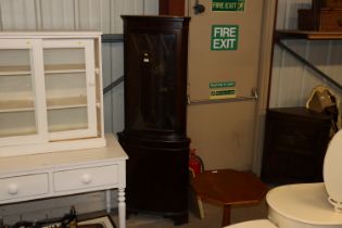 A reproduction floor standing corner cupboard