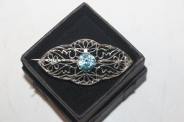 A silver and blue topaz brooch