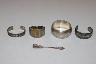 A Russian silver gilt bangle; three white metal ba