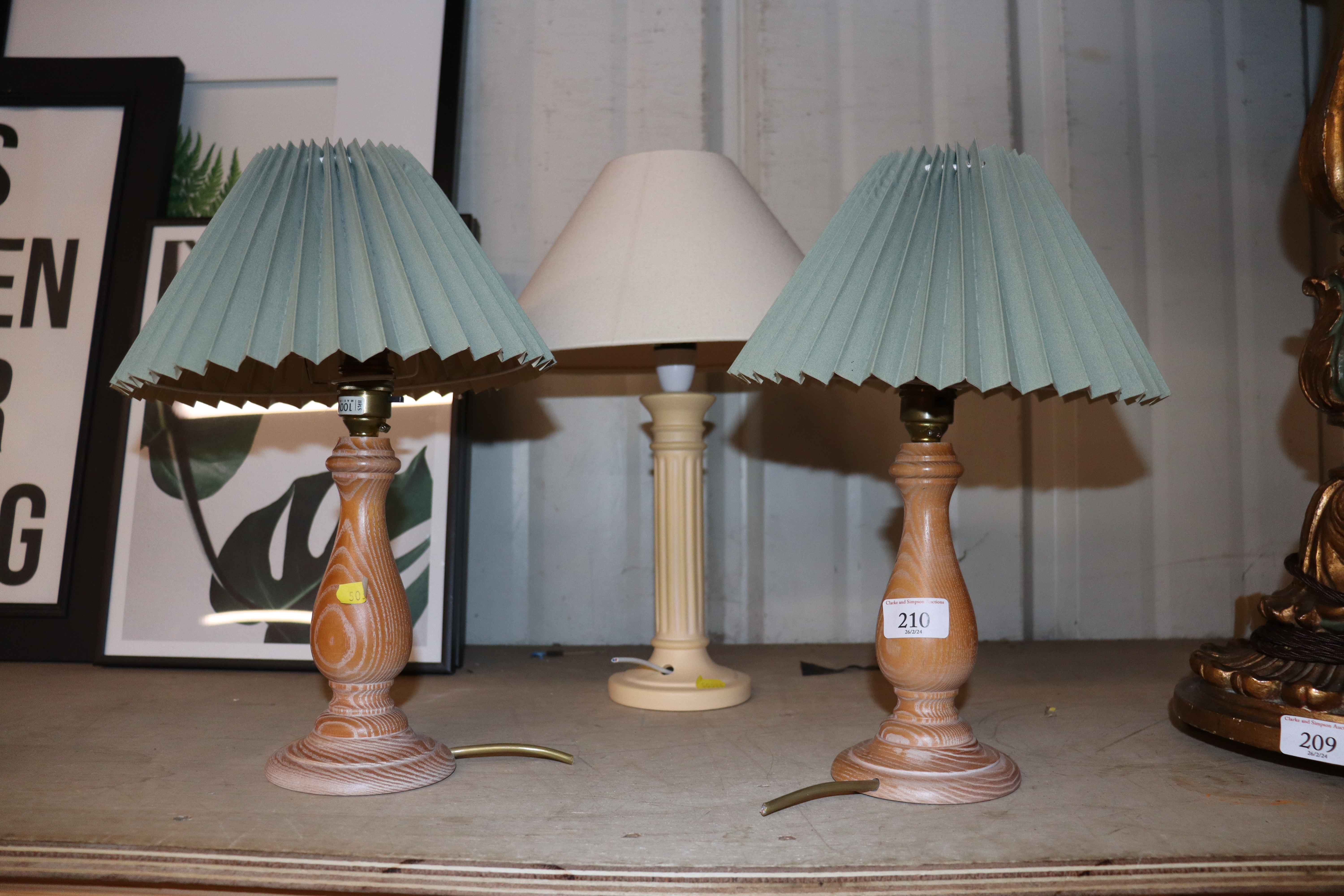 A pair of turned wooden table lamps and another