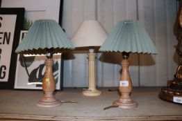 A pair of turned wooden table lamps and another