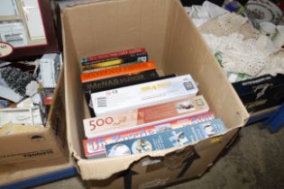 A box containing various board games, puzzles some