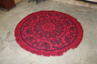 An approx. 5'8" in diameter red/black floral rug