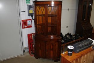 A large half glazed corner cabinet with a cupboard