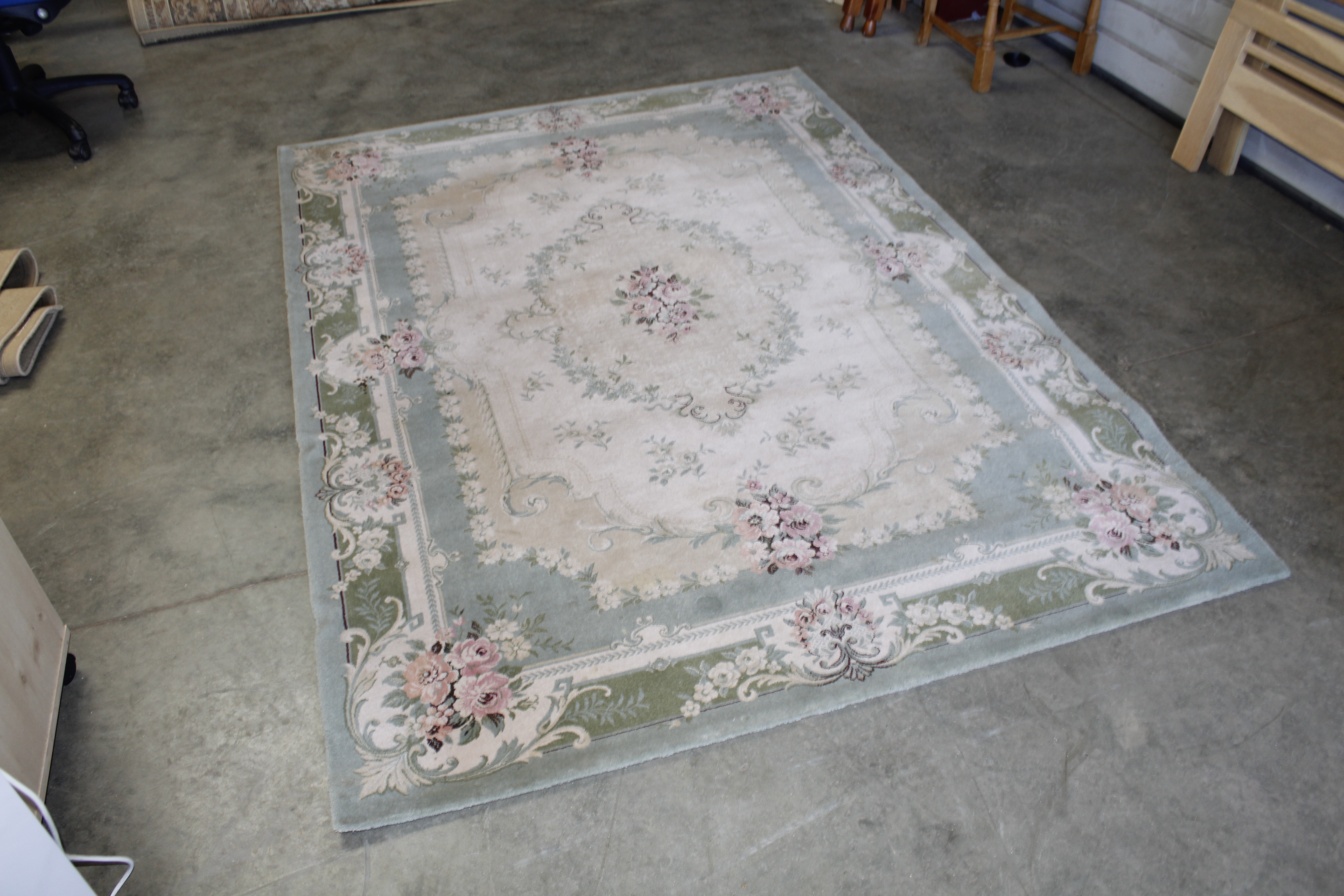 An approx. 7'11" x 5'8" green floral patterned rug