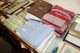 Four bundles of various material, fabrics, towels