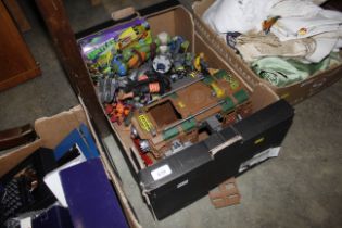 A box containing various toys, action figures, Tee