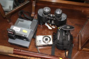 A Polaroid camera; a Nikon digital camera; and a p