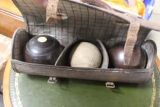 A case containing two bowling woods and a soft bal