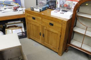 An oak sideboard fitted two short drawers over twin cupboard base